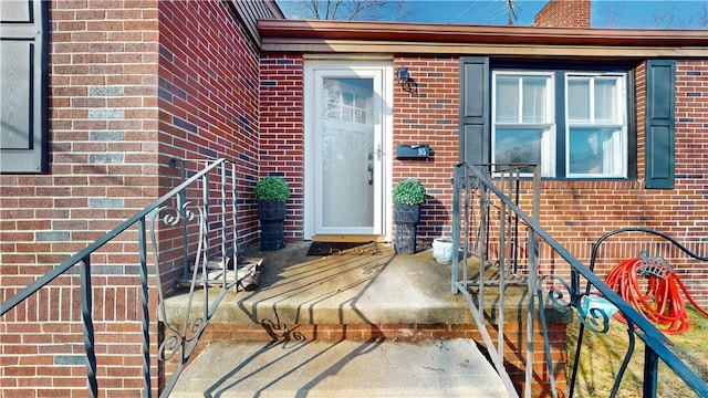 doorway to property with brick siding