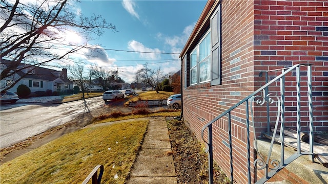 view of side of home featuring brick siding and a residential view