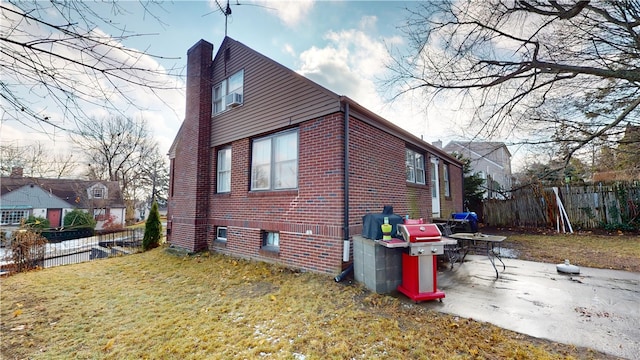 view of side of property featuring brick siding and a chimney