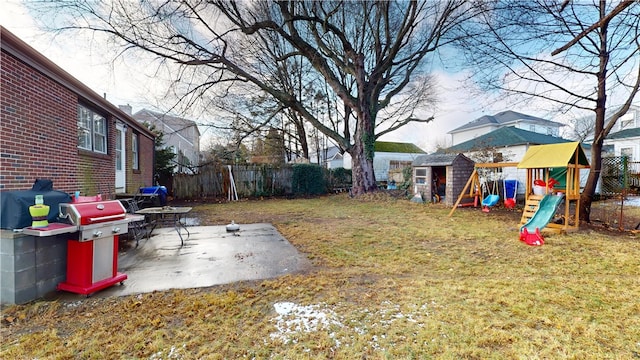view of yard with a storage unit, a playground, a patio area, and an outbuilding