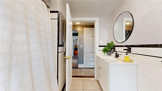 bathroom featuring tile patterned flooring, vanity, tile walls, and curtained shower