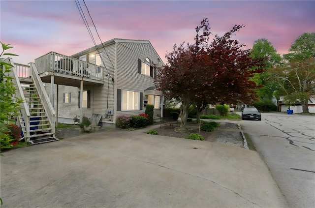 view of property exterior featuring stairway and a deck