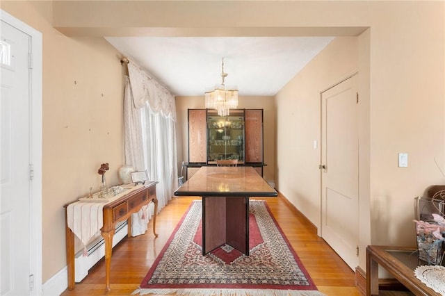 game room with a chandelier, light wood-style floors, and baseboard heating