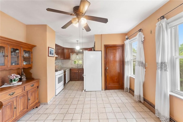 kitchen featuring white appliances, baseboard heating, ceiling fan, and brown cabinetry