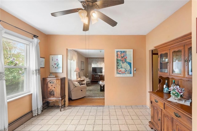 interior space featuring a ceiling fan, a baseboard radiator, and baseboards