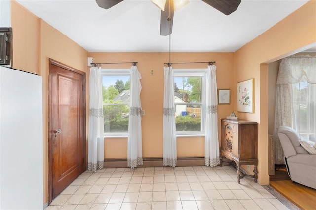 doorway with a ceiling fan and baseboard heating