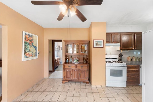 kitchen with white appliances, under cabinet range hood, a ceiling fan, and decorative backsplash