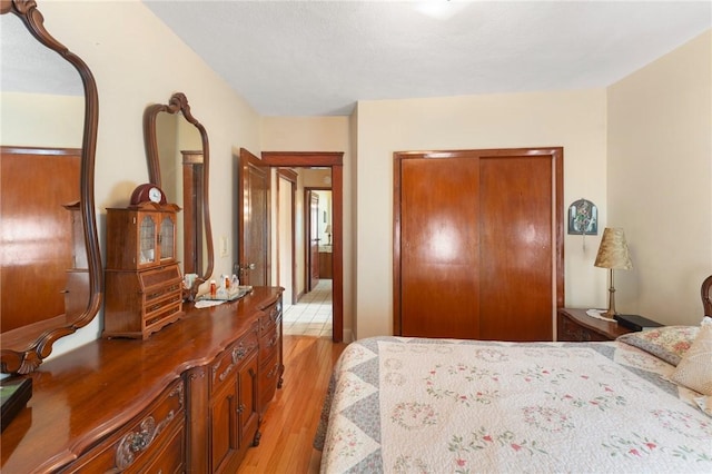 bedroom with light wood-type flooring and a closet