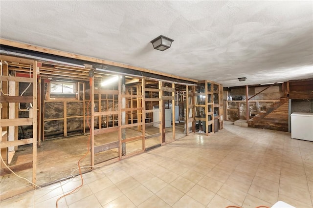 misc room with stairway, a textured ceiling, and washer / clothes dryer
