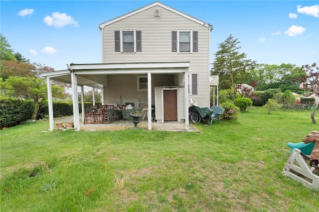 rear view of house featuring a lawn and a patio