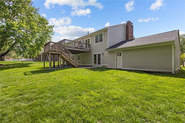 back of house featuring stairs, a deck, a chimney, and a lawn