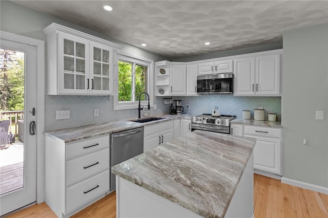 kitchen featuring appliances with stainless steel finishes, a sink, white cabinetry, and recessed lighting