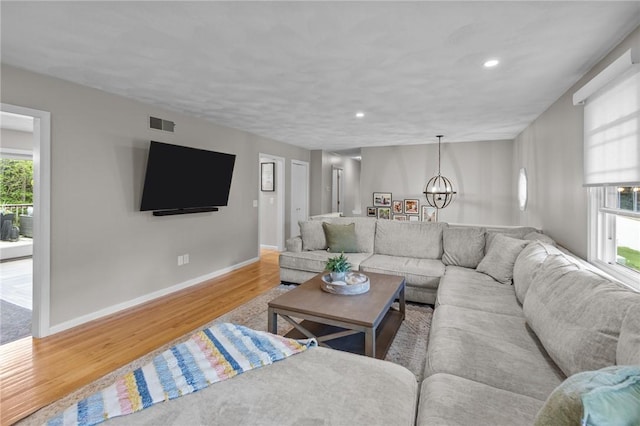 living area featuring wood finished floors, a chandelier, baseboards, and recessed lighting