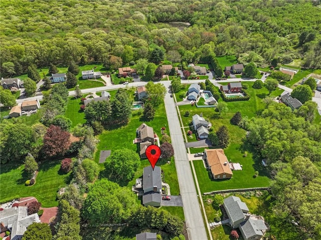 view of property location with a forest and nearby suburban area