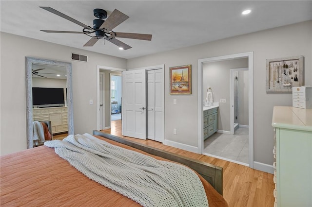 bedroom featuring light wood finished floors, baseboards, recessed lighting, a closet, and ensuite bath