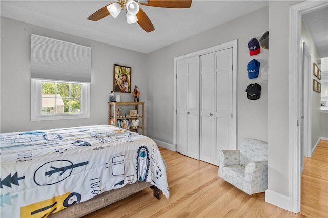bedroom featuring light wood-type flooring, a closet, baseboards, and ceiling fan