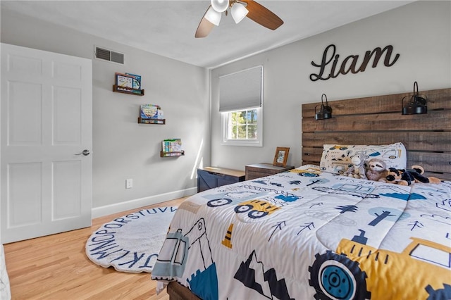 bedroom featuring wood finished floors, baseboards, and a ceiling fan