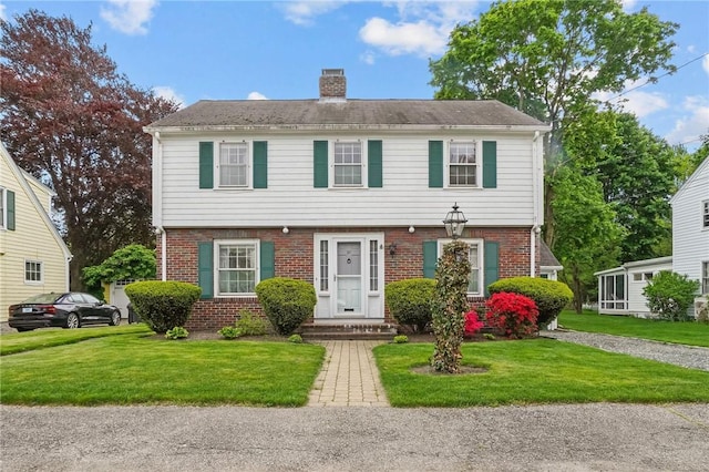 57 Sylvan Rd, East Providence, RI 02916 - colonial-style house featuring a chimney, brick siding, and a front yard