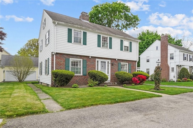 57 Sylvan Rd, East Providence, RI 02916 - colonial home with brick siding, a chimney, a garage, and a front yard