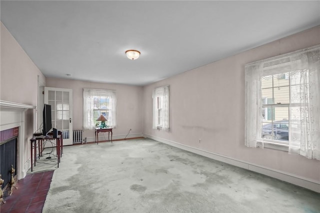 57 Sylvan Rd, East Providence, RI 02916 - unfurnished living room with radiator heating unit, a fireplace with flush hearth, and baseboards