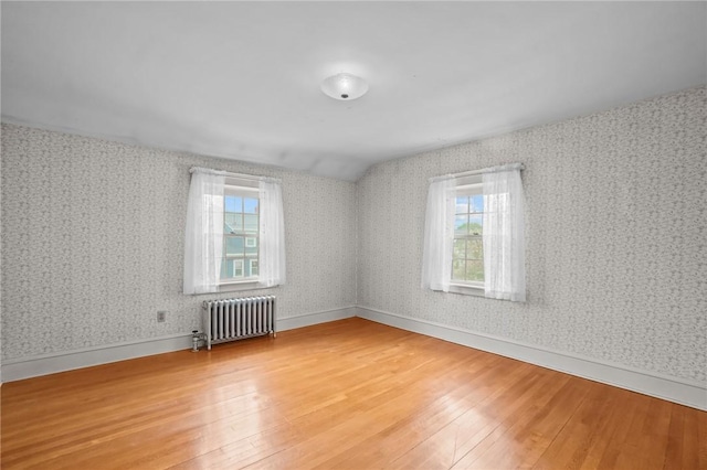 57 Sylvan Rd, East Providence, RI 02916 - unfurnished room with radiator, light wood-type flooring, plenty of natural light, lofted ceiling, and wallpapered walls