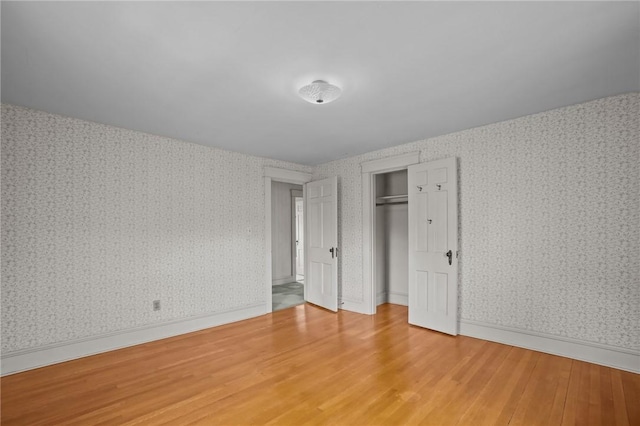 57 Sylvan Rd, East Providence, RI 02916 - unfurnished bedroom with wood finished floors, wallpapered walls, and a closet