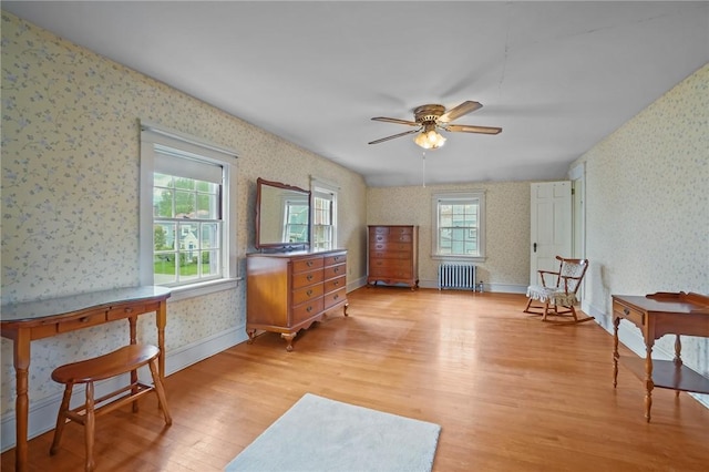 57 Sylvan Rd, East Providence, RI 02916 - living area with radiator heating unit, wallpapered walls, light wood-style flooring, and ceiling fan