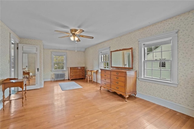 57 Sylvan Rd, East Providence, RI 02916 - bedroom with radiator heating unit, wallpapered walls, light wood-style floors, and multiple windows