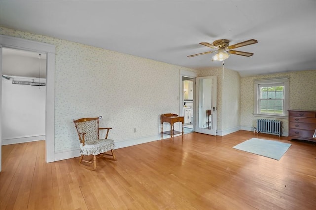 57 Sylvan Rd, East Providence, RI 02916 - unfurnished room featuring radiator heating unit, wallpapered walls, wood finished floors, ceiling fan, and baseboards