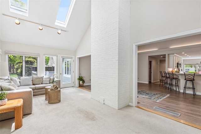 26 Bagy Wrinkle Cv, Warren, RI 02885 - living area with high vaulted ceiling, a skylight, baseboards, track lighting, and wood finished floors