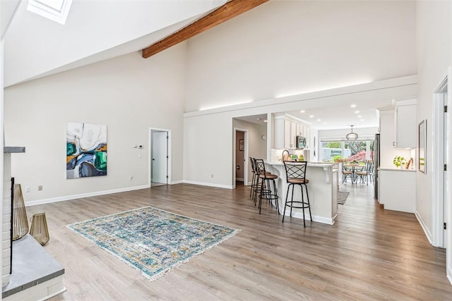 26 Bagy Wrinkle Cv, Warren, RI 02885 - living room with high vaulted ceiling, light wood-type flooring, a skylight, baseboards, and beam ceiling