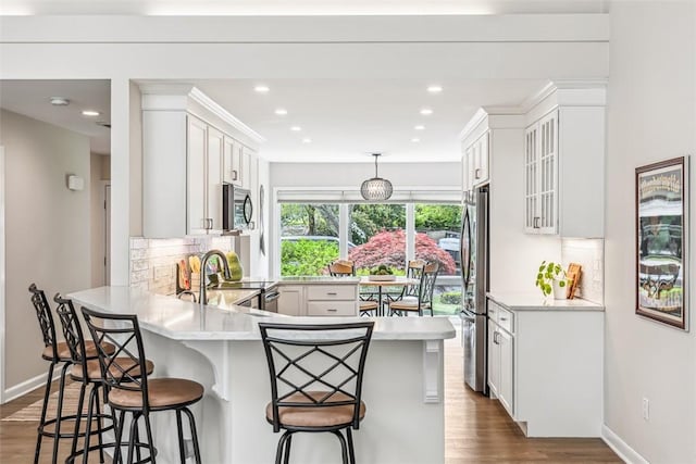 26 Bagy Wrinkle Cv, Warren, RI 02885 - kitchen with stainless steel appliances, light countertops, a peninsula, decorative backsplash, and recessed lighting