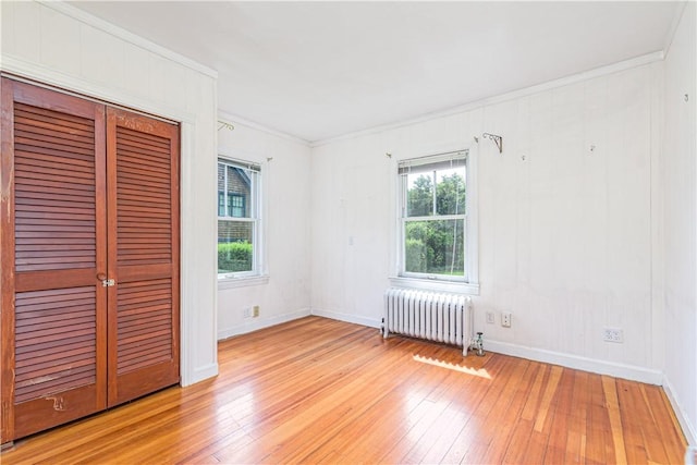 43 Standish Rd, Jamestown, RI 02835 - unfurnished bedroom with radiator heating unit, light wood finished floors, crown molding, baseboards, and a closet