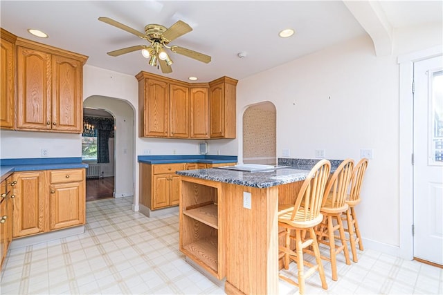 43 Standish Rd, Jamestown, RI 02835 - kitchen with arched walkways, a kitchen breakfast bar, a peninsula, light flooring, and ceiling fan
