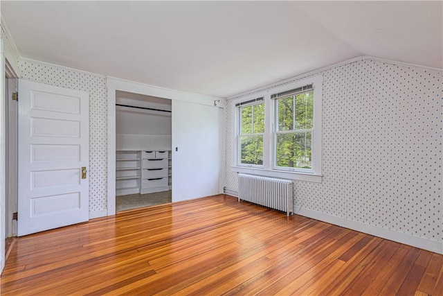 43 Standish Rd, Jamestown, RI 02835 - unfurnished bedroom featuring radiator, wallpapered walls, light wood-style flooring, vaulted ceiling, and a closet