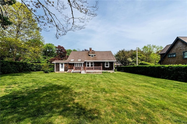 43 Standish Rd, Jamestown, RI 02835 - rear view of property featuring a wooden deck, a yard, and a chimney
