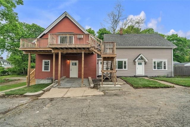 view of front of home with a wooden deck, a chimney, and stairs