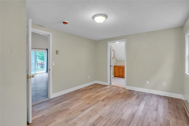 empty room with light wood finished floors and baseboards