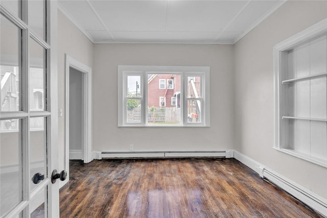 empty room featuring baseboard heating, dark wood-style floors, crown molding, a baseboard heating unit, and baseboards