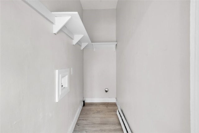 washroom featuring light wood finished floors, baseboards, washer hookup, and baseboard heating