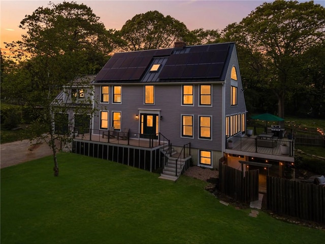 40 Charlotte Ave, North Kingstown, RI 02874 - back of house with solar panels, a wooden deck, a chimney, metal roof, and a standing seam roof