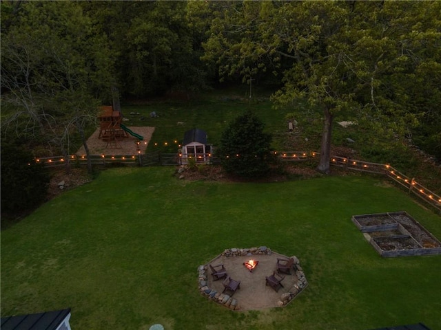 40 Charlotte Ave, North Kingstown, RI 02874 - view of grassy yard with an outdoor fire pit, a garden, a playground, and a wooded view