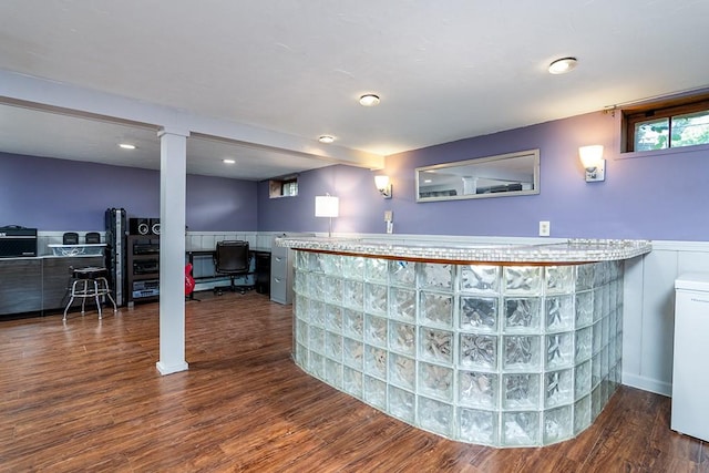 indoor dry bar featuring a wainscoted wall and wood finished floors