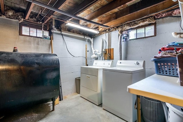 clothes washing area featuring heating fuel, washer and clothes dryer, and healthy amount of natural light