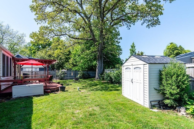 view of yard featuring a shed, an outbuilding, and a deck