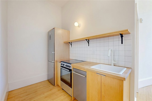 kitchen featuring a sink, open shelves, stainless steel electric range oven, light wood finished floors, and backsplash
