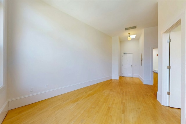 spare room featuring light wood finished floors and baseboards