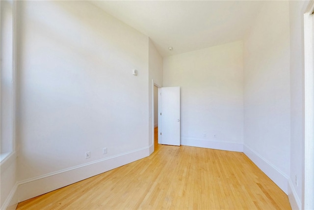 spare room with wood finished floors and baseboards
