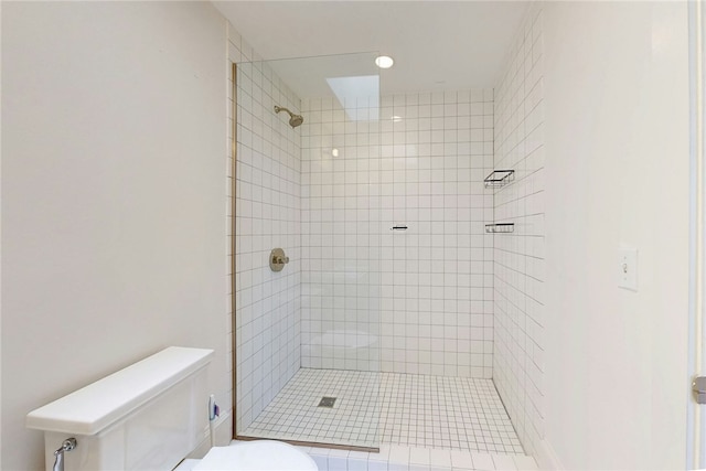 full bath featuring toilet and a tile shower