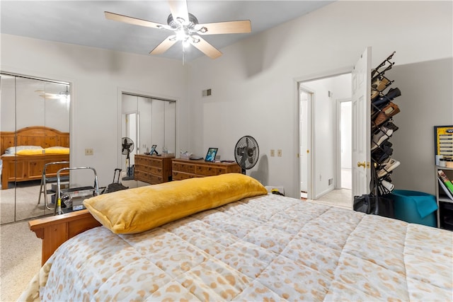bedroom featuring carpet, two closets, and a ceiling fan